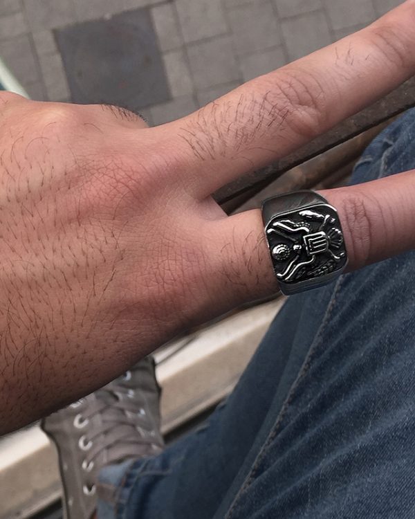 הדוגמן עונד טבעת חותם מרובע בעל צורת נשר בצבע שחור כסף מושחר